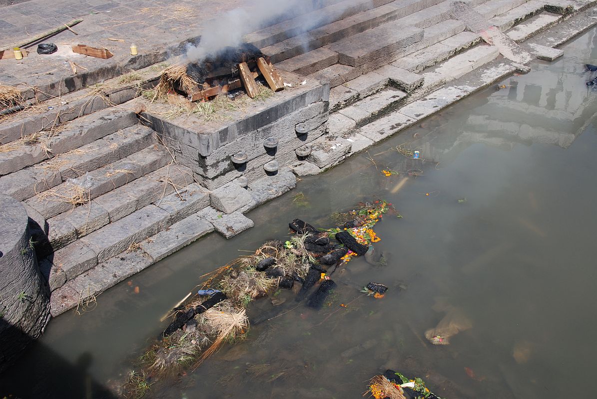 Kathmandu Pashupatinath 10 Burning Ghat At Edge of River The wood and whats left of the burned body are dumped into the Bagmati River after the cremation at Pashupatinath in Kathmandu is over.